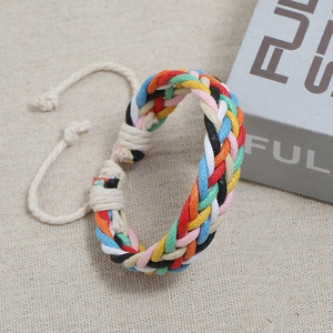 Detailed view of colorful hand-woven braided friendship bracelet on textured linen fabric