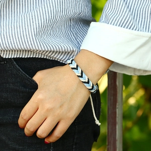 Handmade woven friendship bracelet in blue, white, and black cotton cord style