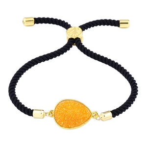 Detailaufnahme der schwarzen Kordelarmband mit goldenem Schieber und orangefarbenem Kristall