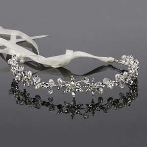 Detail of flower headband with white pearls and sparkling crystals on silk ribbon