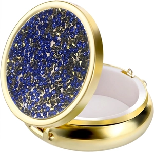 Close-up of golden pill box featuring star-patterned rhinestones and internal dividers