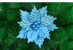 Detail of blue glitter Christmas flower with multi-layer petals on green pine branches