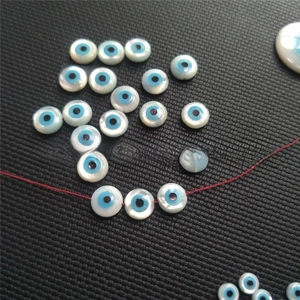 Detailed view of natural white mother of pearl evil eye beads for DIY jewelry making