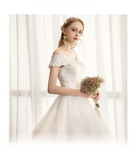 Exquisite lace embroidery and off-shoulder detail on a white Hepburn style wedding dress