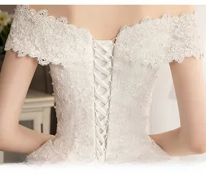 Detail of bridal gown back showing lace trim, pearl edges, and adjustable satin corsetry