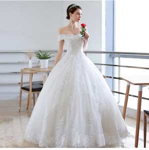 Detail of off-shoulder wedding gown featuring exquisite lace embroidery and a ballgown skirt