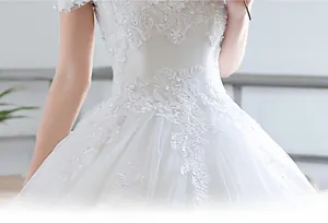 Detail of white wedding gown showing lace floral patterns and sparkling sequins on waist