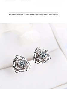 Macro shot of silver rose earrings with sparkling cubic zirconia center inlay