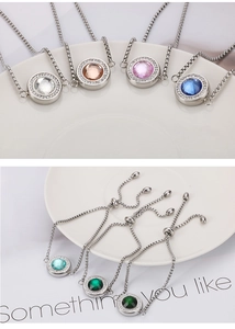 Gros plan de pendentifs en cristal coloré avec halos étincelants sur chaînes argentées
