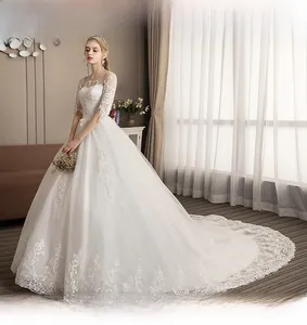 Detail of off-the-shoulder neckline with intricate lace embroidery on white bridal gown