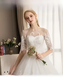 Detail of elegant white wedding dress with swan embroidery and lace sleeves