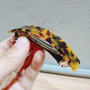 Close-up of amber leopard print curved hair clip with sturdy metal spring fastener