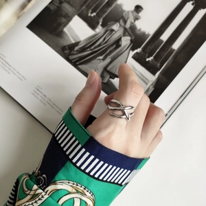 Detailed view of silver braided multi-layer ring styled on hand with fashion magazine