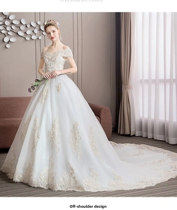 Close-up of off-shoulder wedding dress with gold lace floral embroidery and long train
