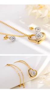 Detail shot of golden hollow heart necklace and crystal ball stud earrings jewelry set