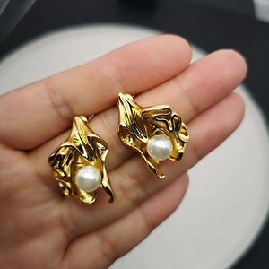 Artistic gold flower pearl earrings with textured brass petals and smooth pearls