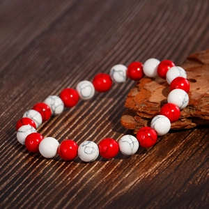8mm red and white marbled stone bead elastic bracelet displayed on dark wood background