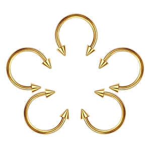 Detailed view of five gold horseshoe piercing rings with spikes on a clean white background