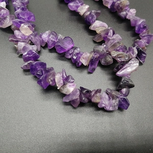 Close-up of polished irregular natural amethyst stone beads on a crystal necklace