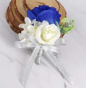 Detailopname van koningsblauwe kunstmatige rozen corsage met witte bloemen en glitterlint