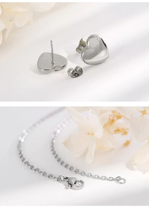 Close-up of silver heart stud earrings and necklace chain with lobster clasp details