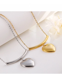 Detail of elegant gold and silver heart pendants with curved tubes on fine link chains