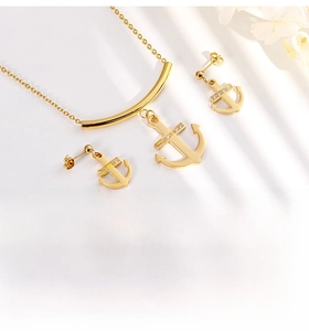 Gros plan sur un ensemble collier et boucles d'oreilles ancre dorée avec zircon cubique