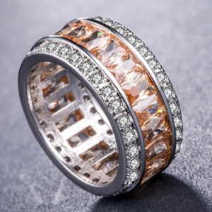 Macro detail of wide ring with rectangular champagne gems and pavé zircon borders