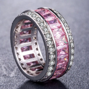 Macro shot of silver ring with rectangle pink zircons and white round crystals detailing