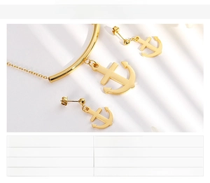 Detail view of gold anchor jewelry set including necklace and earrings in stainless steel