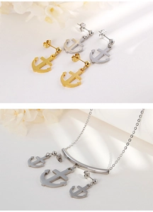 Detail showing gold and silver anchor earrings and necklace set on white floral background