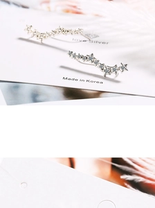 Close-up of star-shaped earrings with sparkling cubic zirconia on white card