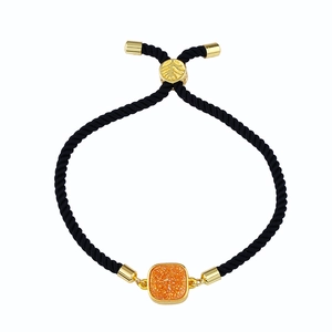 Détail du bracelet réglable en corde noire avec pendentif en cristal orange carré