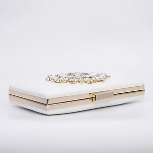 Elegant white evening clutch bag featuring gold crystal flower clasp and metal frame