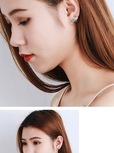 Close-up of heart-shaped light blue zircon ear cuff with silver finish on ear