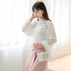 Elegant white evening bag with circular rhinestone decor and gold chain strap shown by a model