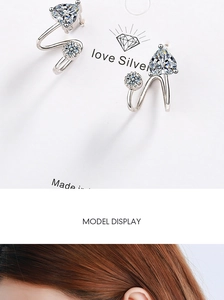 Detail view of heart-shaped zircon earrings in silver finish on card and model ear