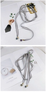 Détail de l'écharpe étroite en soie argentée avec pendentifs en cristal dégradé violet et bleu