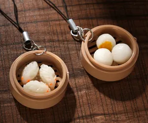 Macro shot of realistic shrimp dumpling and bun pendants in mini plastic steamers