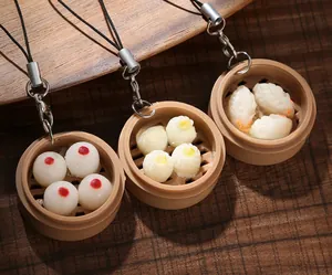 Macro detail of simulation dim sum steamer keychains with shumai and dumpling models