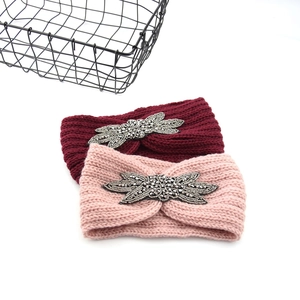 Nahaufnahme des Strickstirnbands mit Blatt-Strassstein und eleganter Perlenverzierung