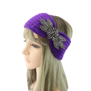 Detail eines lila Strickstirnbandes mit aufwendigen, funkelnden Perlenstickereien