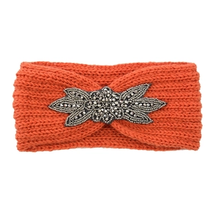 Detail eines orangen Strickstirnbandes mit exquisiter silberner Perlenblume verziert