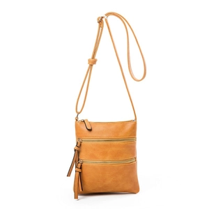 Detail of tan pebble PU leather crossbody bag featuring triple front zipper pockets and long tassels