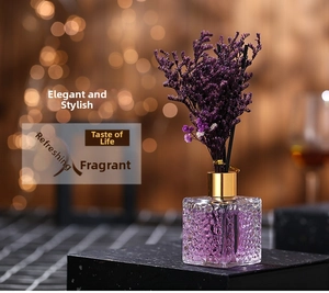 Detail of lavender reed diffuser set in a square glass bottle with dried flowers
