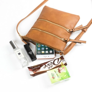 Detail showing the brown multi-zipper crossbody bag with large capacity storage