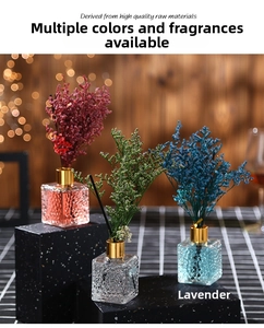 Detail of luxury reed diffuser set with colored dried flowers and gold caps in glass bottles