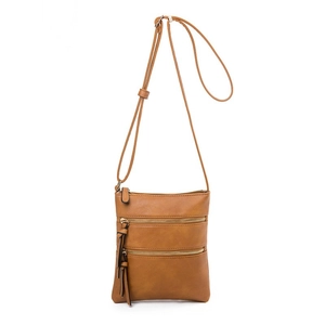 Detail view of caramel faux leather crossbody bag with triple front zippers and retro style