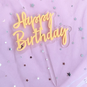 Colorful double-layer acrylic Happy Birthday cake topper on a pink starry mesh background