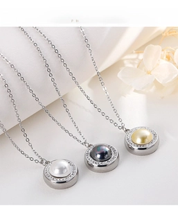 Detailed macro of pearl pendant necklaces with sparkling crystal halo on white fabric